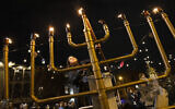 Illustrative: Rabbanit Dasi Fruchter, of the South Philadelphia Shtiebel, lights a menorah during a public Hanukkah celebration and menorah lighting ceremony in South Philadelphia on Sunday, Dec. 5, 2021. (AP Photo/Ryan Collerd)