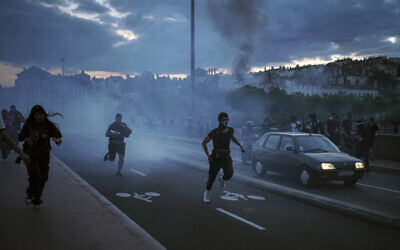 People run away during clashes with police in the center of Lyon, central France, Friday, June 30, 2023. (AP/Laurent Cipriani)