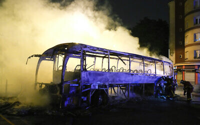 Firefighters use a water hose on a burnt bus in Nanterre, outside Paris, France, July 1, 2023. (AP Photo/Lewis Joly)