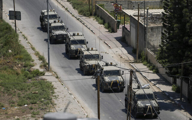 A convoy of army vehicles is seen during an Israeli military raid in Jenin refugee camp in the West Bank, July 3, 2023. (AP Photo/Majdi Mohammed)