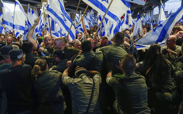 Israeli Border Police officers try disperse demonstrators trying to block the entrance to Israel's main international airport during a protest against plans by Prime Minister Benjamin Netanyahu's government to overhaul the judicial system, at Ben Gurion Airport in Lod, near Tel Aviv, Israel, July 3, 2023. (AP Photo/ Ohad Zwigenberg)