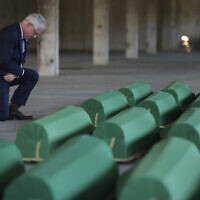 United States Ambassador to Bosnia and Herzegovina Michael J. Murphy kneels next to the coffins containing remains of 30 newly identified victims of the Srebrenica Genocide in Potocari, Bosnia, July 10, 2023. (AP/Armin Durgut)