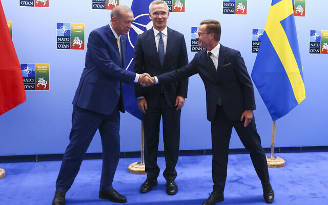 Turkey's President Recep Tayyip Erdogan, left, shakes hands with Sweden's Prime Minister Ulf Kristersson, right, as NATO Secretary General Jens Stoltenberg looks on prior to a meeting ahead of a NATO summit in Vilnius, Lithuania, Monday, July 10, 2023. (Yves Herman, Pool Photo via AP)