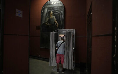 A voter stands in a booth at a polling station for Spain's general election, in Madrid, July 23, 2023. (Paul White/AP)