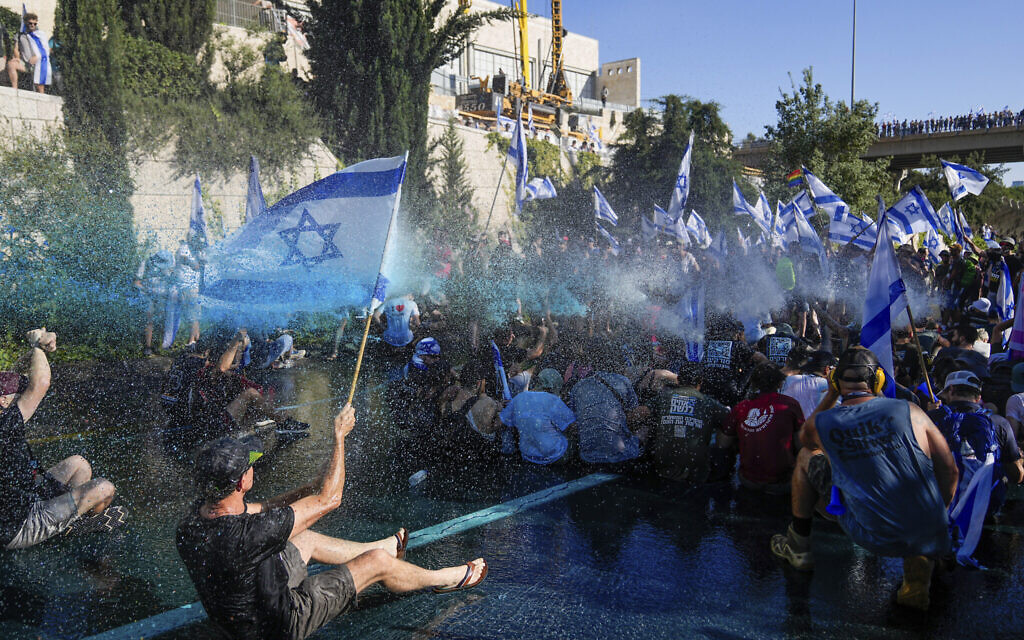 Israeli police use a water cannon to disperse demonstrators blocking a road during a protest against moves by Prime Minister Benjamin Netanyahu's government to overhaul the judicial system, in Jerusalem, July 24, 2023. (AP Photo/Ohad Zwigenberg)
