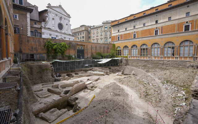 People walk in the excavation site of the ancient Roman emperor Nero's theater, 1st century AD, backdropped by the church of Santo Spirito in Sassia, during a press preview, in Rome, Wednesday, July 26, 2023 (AP Photo/Andrew Medichini)