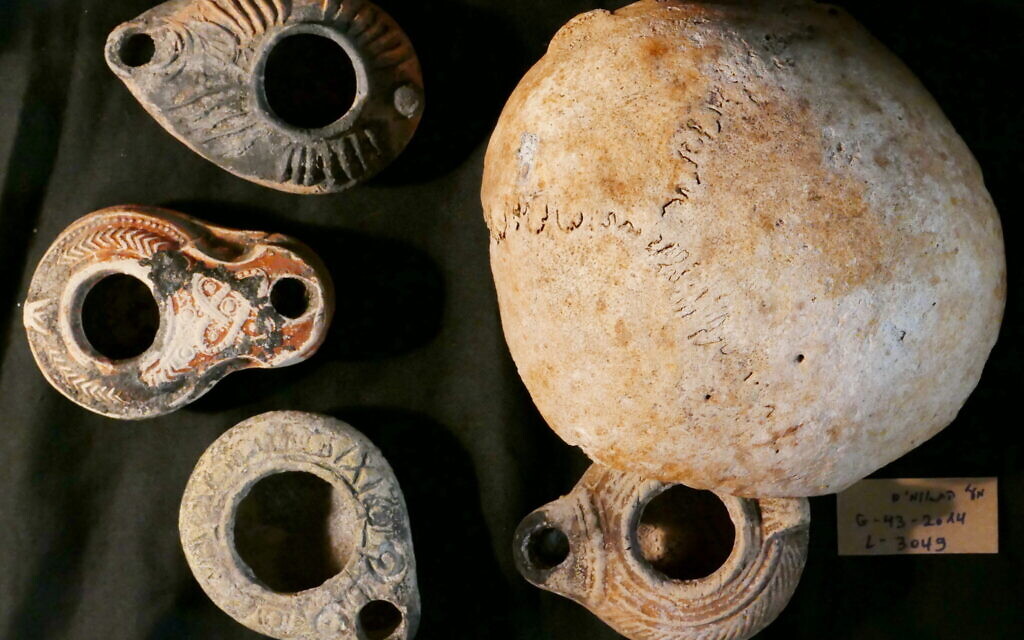 A collection of oil lamps and the upper part of a human skull discovered in Teumim Cave near Beit Shemesh. (courtesy Boaz Zissu)