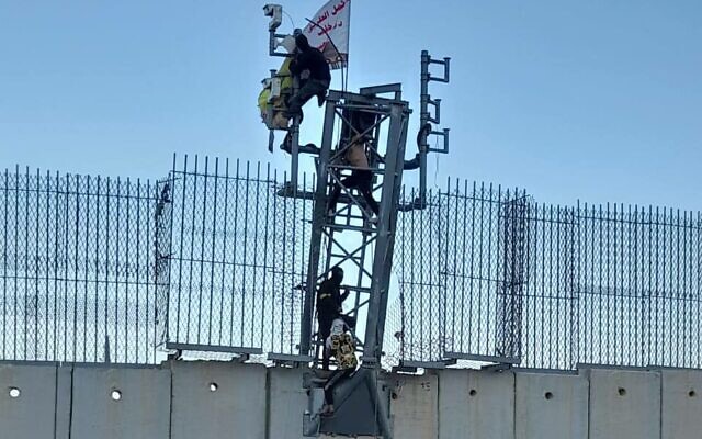 Hezbollah activists climb an Israeli surveillance tower on the border with Lebanon, July 12, 2023. (Social media: used in accordance with Clause 27a of the Copyright Law)