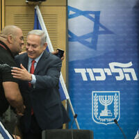 Prime Minister Benjamin Netanyahu (center) embraces Likud activist Itzik Zarka during a party faction meeting at the Knesset on July 9, 2018 (Hadas Parush/Flash90)