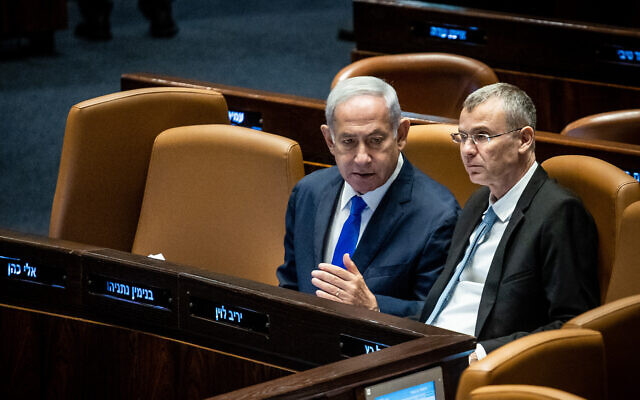 Prime Minister Benjamin Netanyahu speaks with Justice Minister Yariv Levin (R) at the Knesset on June 7, 2023. (Oren Ben Hakoon/Flash90)