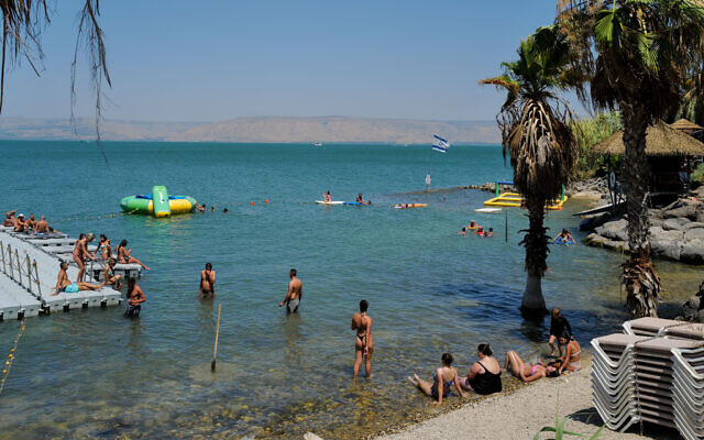 Israelis and tourists cool off in the Sea of Galilee near Tiberias on June 28, 2023. (Michael Giladi/Flash90)
