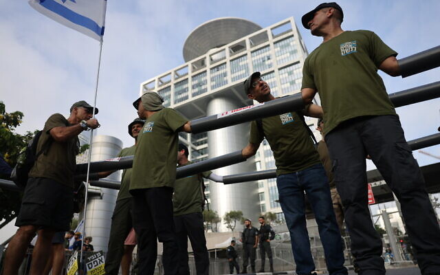 Demonstrators block the entrance to the Defense Ministry in Tel Aviv as they protest the government's judicial overhaul plans, on July 18, 2023. (Chaim Goldberg/Flash90)