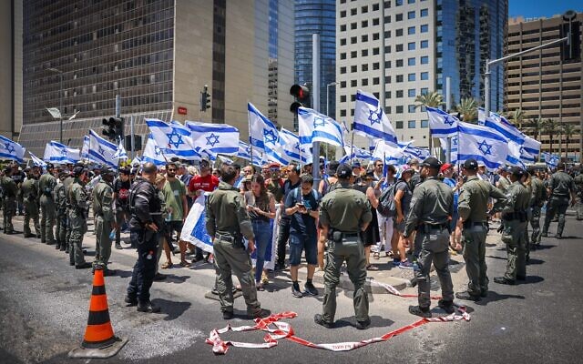 Police stand in front of protesters against the judicial overhaul in Ramat Gan, July 18, 2023. (Chaim Goldberg/Flash90)