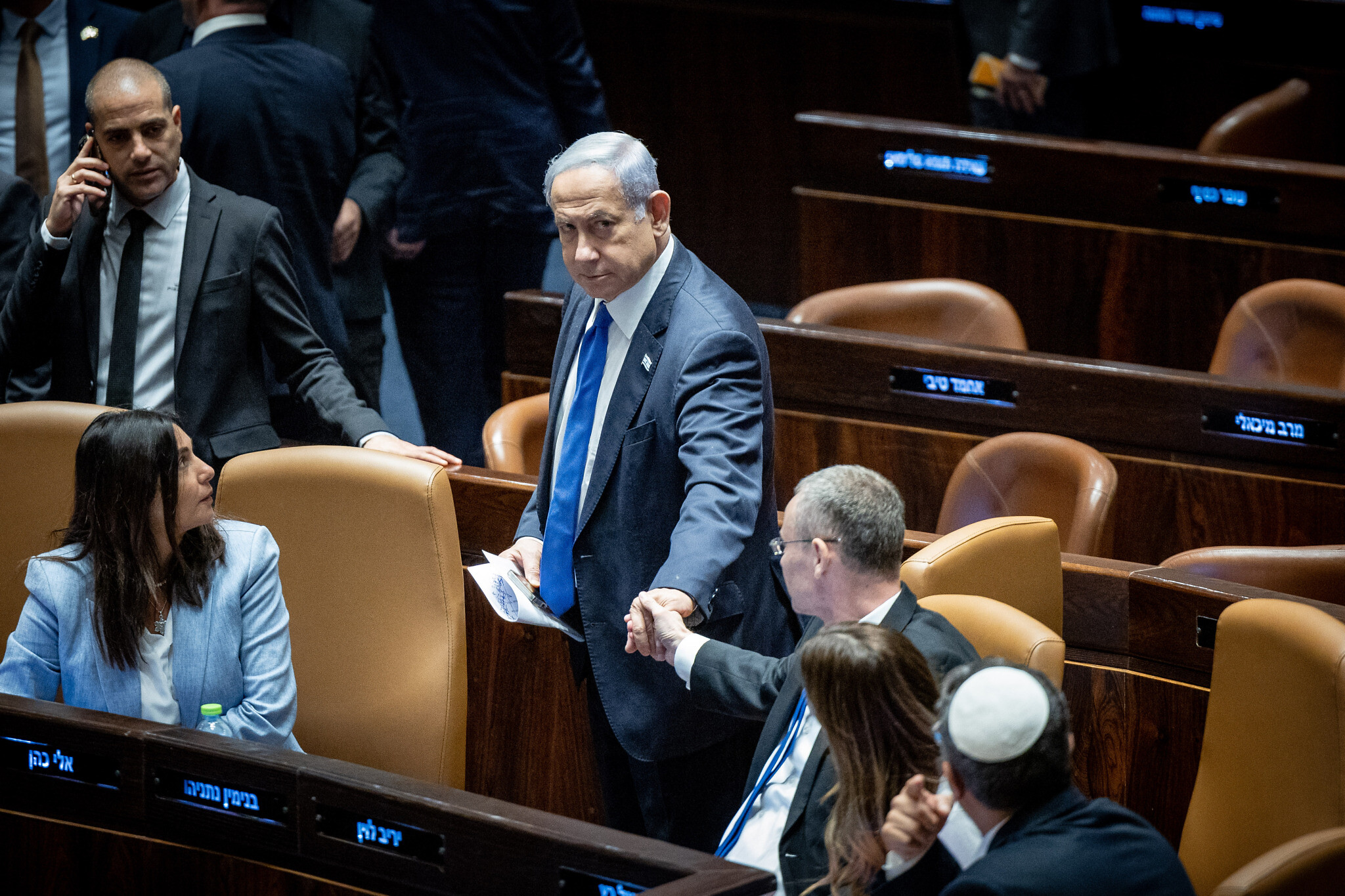 Prime Minister Benjamin Netanyahu shakes hands with Justice Minister Yariv Levin as the Knesset votes to enact the 'reasonableness' law, July 24, 2023. (Yonatan Sindel/Flash90)