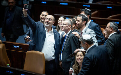 Coalition lawmakers crowd around Justice Minister Yariv Levin to take a celebratory selfie in the Knesset plenum, as they pass the first of the coalition's judicial overhaul laws, the so-called "reasonableness law", on July 24, 2023. (Yonatan Sindel/Flash90)