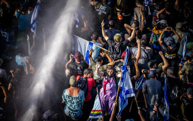 Police use a water cannon on anti-overhaul activists blocking Begin Road in Jerusalem, as they protest against the government's judicial overhaul, near the Knesset in Jerusalem, on July 24, 2023. (Yonatan Sindel/Flash90)