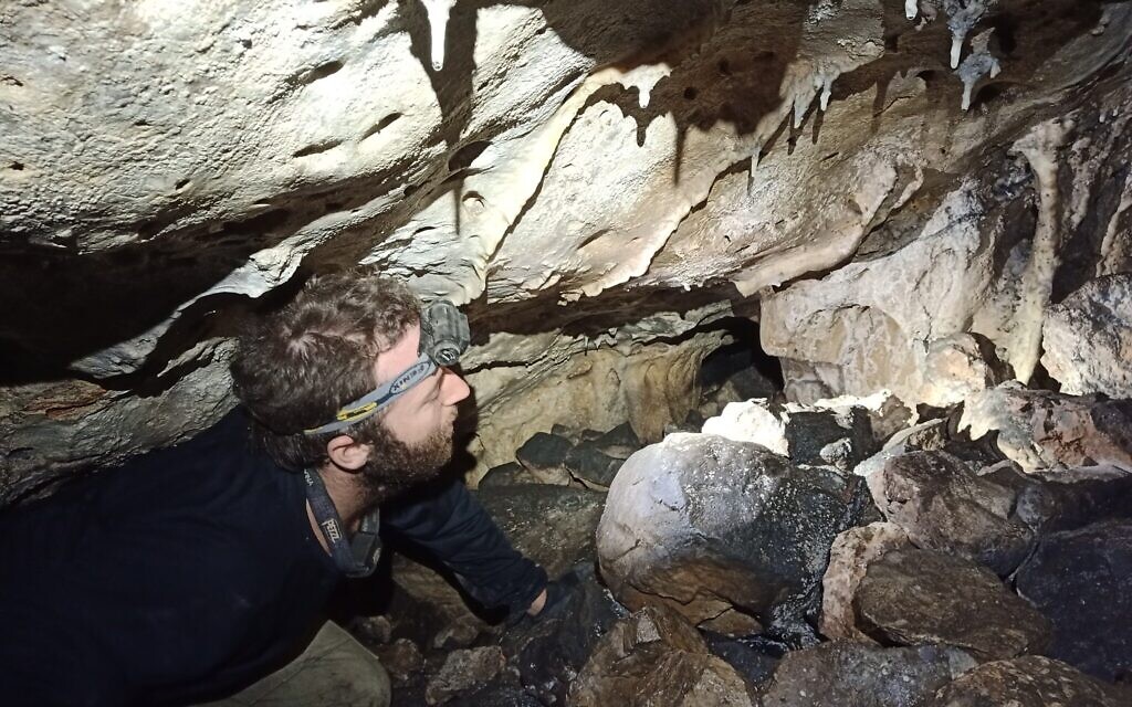 Shemesh Yaaran exploring a crevice in the Teomim Cave in the Jerusalem Hills. (courtesy Boaz Zissu)