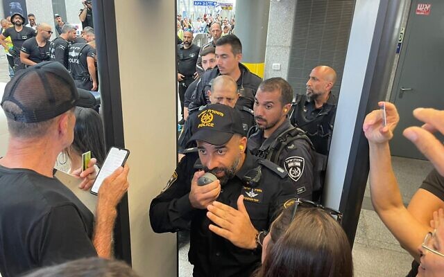 Police officer Meir Suissa orders demonstrators to leave as they are blocked from entering Tel Aviv's Hashalom train station on July 18, 2023 (Carrie Keller-Lynn/Times of Israel)