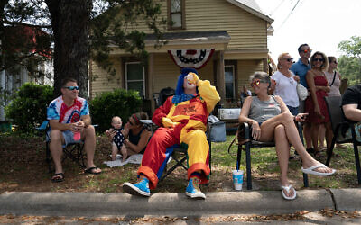 A clown rests in the heat with some cold water while he participates in the annual Independence Day Parade on July 4, 2023 in Southport, North Carolina. (Allison Joyce / Getty Images via AFP)