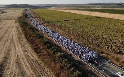 Marchers along Route 424 on Thursday evening, July 20 2023, on the way to Kibbutz Nahshon where they spent their third night during the march to Jerusalem. (Gitai Palti)