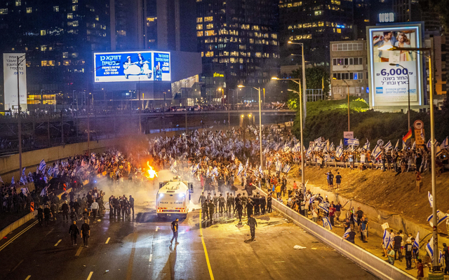 Israelis block the Ayalon Highway during a protest against the government's planned judicial overhaul and in response to the removal of Tel Aviv District Commander Amichai Eshed in Tel Aviv, July 5, 2023. (Yossi Aloni/Flash90