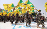 File: Members of Iraqi Kataeb Hezbollah marching in military uniforms step on a representation of an Israeli flag in Baghdad, Iraq, July 25, 2014, during the annual 'Jerusalem Day' march. (AP/Hadi Mizban)