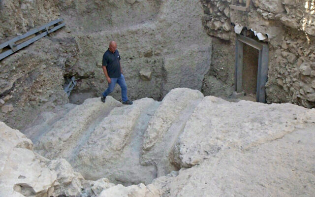 Dr. Yiftah Shalev examines mysterious ancient channels uncovered in the City of David, Jerusalem, August 2023. (Emil Aladjem/IAA)