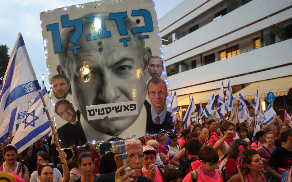 Protesters lift flags and placards during a rally against the government's judicial overhaul plans in Tel Aviv on August 12, 2023. (JACK GUEZ/AFP)