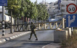 An Israeli soldier mans a checkpoint at the closed-off southern entrance to the southern West Bank city of Hebron, on August 22, 2023, a day after a deadly terror shooting in the area. (Hazem Bader/AFP)
