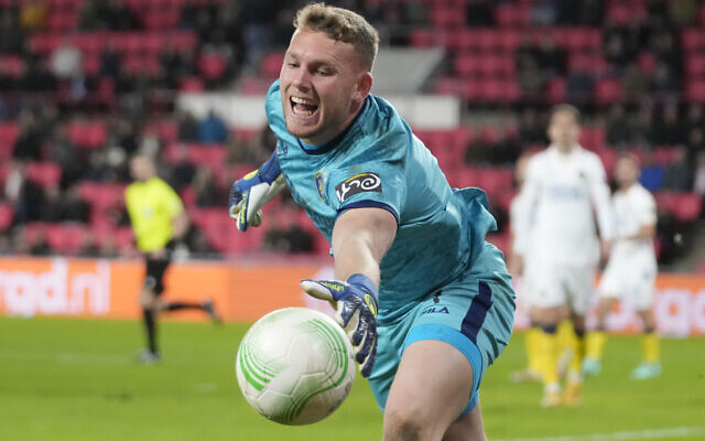 Maccabi Tel Aviv goalkeeper Daniel Peretz tries to keep the ball inside during the first leg playoff Conference League soccer match between PSV and Maccabi Tel Aviv at the Philips stadium in Eindhoven, Netherlands, Thursday, Feb. 17, 2022. (AP Photo/Peter Dejong)