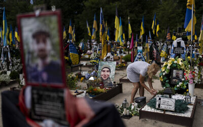 Natalie Zaichenko, 60, tends to the grave of her son, a Ukrainian soldier who was killed in the war against Russia, in Kyiv, Ukraine, August 3, 2023. (AP Photo/Jae C. Hong)