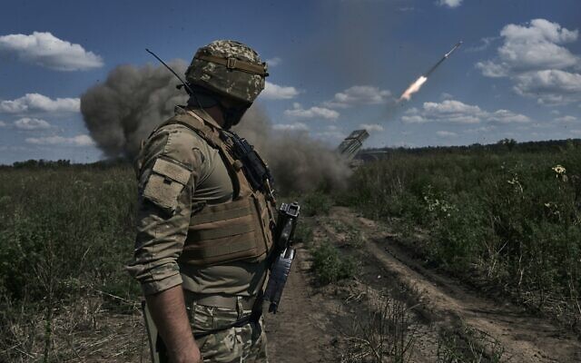 A Ukrainian soldier watches a Grad multiple launch rocket system firing near Bakhmut, Donetsk region, Ukraine, August 13, 2023. (Libkos/AP)