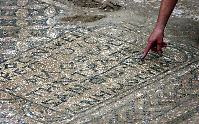 An Israeli archaeologist points at a nearly 1,800-year-old decorated floor from an early Christian prayer hall that Israeli archaeologists discovered adjacent to Megiddo prison, on November 6, 2005. (Ariel Schalit/AP)