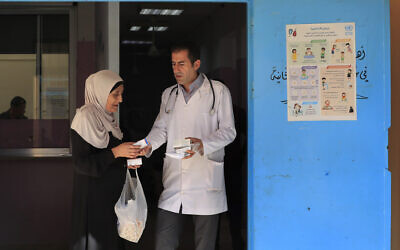 File: A Palestinian woman receives medicine from a doctor at a clinic run by the agency for Palestinian refugees, or UNRWA, in the Ein el-Hilweh refugee camp in the southern port city of Sidon, Lebanon, June 20, 2023. (AP Photo/Mohammed Zaatari)
