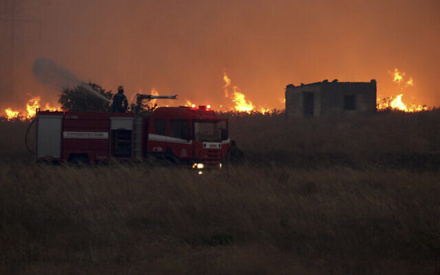 A firefighter fighting a wildfire near the northeastern town of Alexandroupolis, Greece, August 20, 2023. (Ilias Kotsireas/ InTime News via AP) A firefighter fighting a wildfire near the northeastern town of Alexandroupolis, Greece, August 20, 2023. (Ilias Kotsireas/ InTime News via AP)