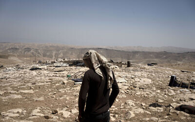 Palestinian shepherd Mustafa Arara, 24, stands in the ruins of the West Bank Bedouin village of al-Baqa, demolished by its residents when they left in July after settlers established an outpost a stone's throw from the village in June, August 9, 2023. (AP Photo/Maya Alleruzzo)