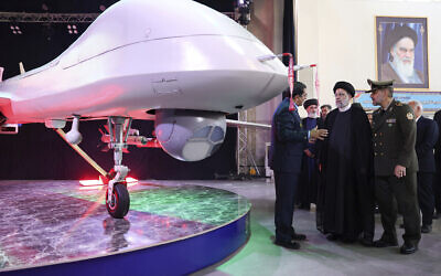Iran's President Ebrahim Raisi, second right, listens to Chief of Aviation Industries of Armed Forces Gen. Afshin Khajehfard, as Defense Minister Gen. Mohammad Reza Gharaei Ashtiani, right, listens, during a ceremony unveiling a drone called the Mohajer-10, August 22, 2023. (Iranian Presidency Office, via AP)