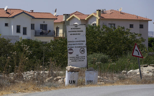A United Nations sign and barrels on the side of a road inside the UN buffer zone at the village of Pyla in Larnaca district of the divided Mediterranean island of Cyprus, on August 21, 2023. (Petros Karadjias/AP)