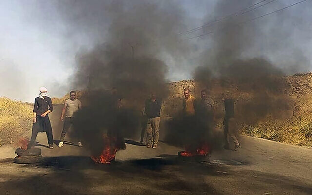 In this photo released by Suwayda24, people stage a protest in the southern city of Sweida, Syria, August 22, 2023. (Suwayda24 via AP)