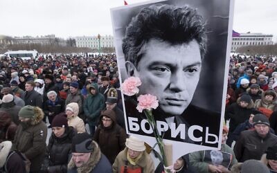 In this Sunday, Feb. 26, 2017 file photo, People gather in memory of opposition leader Boris Nemtsov, portrait in center, in St. Petersburg, Russia. Once deputy prime minister under Boris Yeltsin, Nemtsov was a popular politician and harsh critic of Putin. On a cold February night in 2015, he was gunned down by assailants on a bridge adjacent to the Kremlin as he walked with his girlfriend in a death that sent shockwaves across the country. (AP/Dmitri Lovetsky, file)
