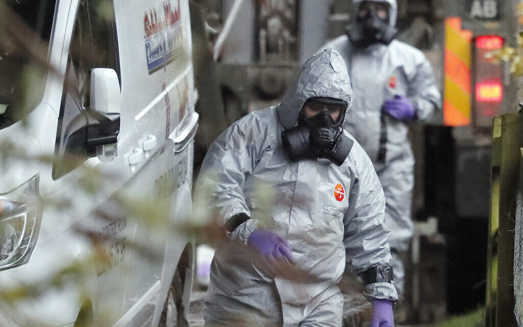 In this March 12, 2018 file photo personnel in protective gear work on a van in Winterslow, England, as investigations continue into the nerve-agent poisoning of Russian ex-spy Sergei Skripal and his daughter Yulia, in Salisbury, England. The Skripals fell ill and spent weeks in critical condition. They survived, but the attack later claimed the life of a British woman and left a man and a police officer seriously ill. Authorities said they both were poisoned with the military grade nerve agent Novichok. (AP/Frank Augstein, File)
