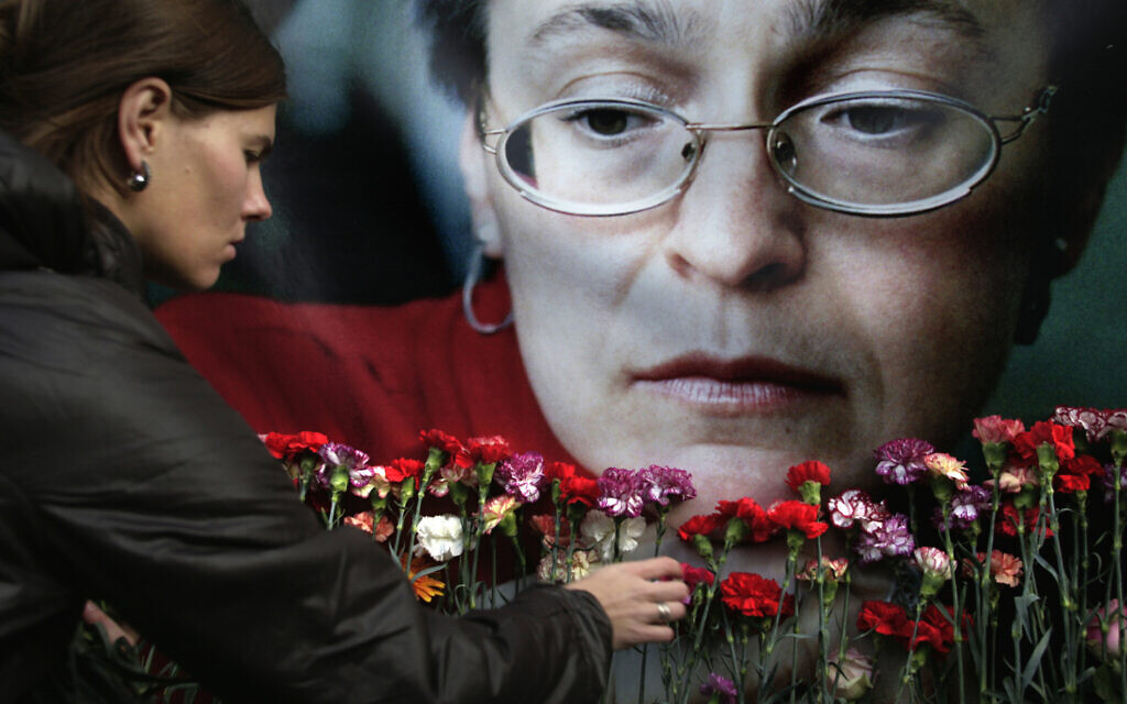 In this Oct. 7, 2009 file photo, a woman places flowers before a portrait of slain Russian journalist Anna Politkovskaya, in Moscow. The journalist for the newspaper Novaya Gazeta whose death Litvinenko was investigating, was shot and killed in the elevator of her Moscow apartment building on Oct. 7, 2006. (AP/Pavel Golovkin, File)