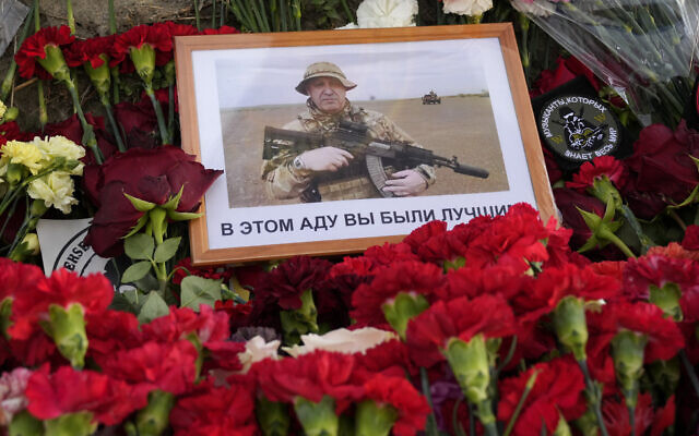 An image of the owner of private military company Wagner Group, Yevgeny Prigozhin, with words in Russian 'In this hell you were the best' lies at an informal memorial next to the former 'PMC Wagner Centre' in St. Petersburg, Russia, August 25, 2023. (AP Photo/Dmitri Lovetsky)