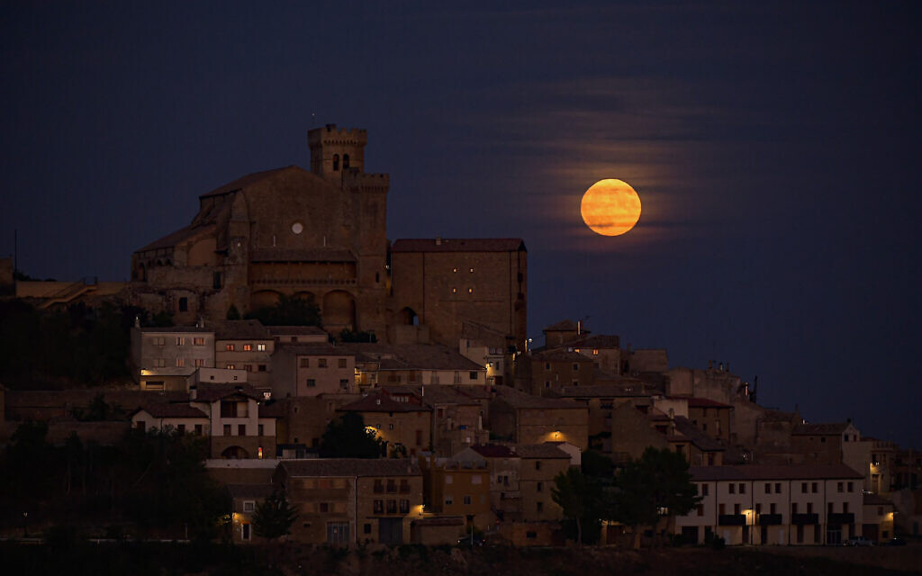 A rare blue supermoon rises behind the small village of Ujue, northern Spain, August 30, 2023. (lvaro Barrientos/AP)