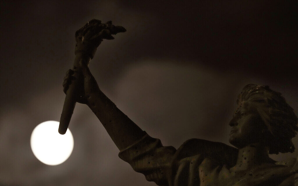 The full moon rises beyond the Martyrs statue, in downtown Beirut, Lebanon, August 30, 2023. (Hussein Malla/AP)