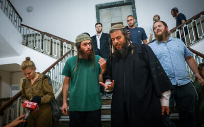 Elisha Yered, left, seen at the Jerusalem District Court after being released to house arrest on August 9, 2023. (Chaim Goldberg/Flash90)