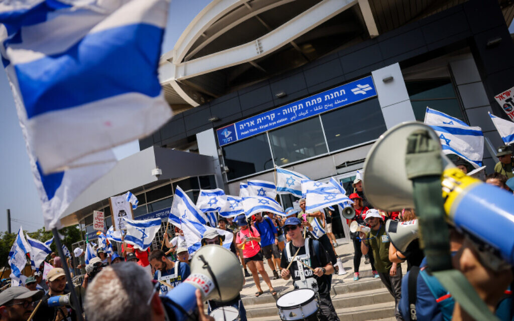 Anti-overhaul activists protest ahead of the opening ceremony of the light rail in Petah Tikva, August 17, 2023. (Chaim Goldberg/Flash90)