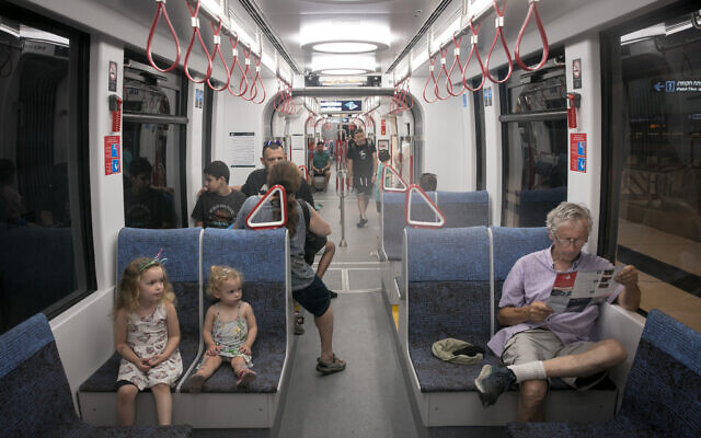 Passengers ride the Tel Aviv light rail on its first day of service, August 18, 2023. (Miriam Alster/Flash90)