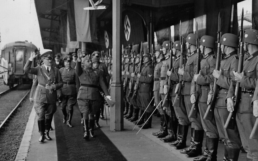 Hitler and Francisco Franco give the Nazi salute as they walk by German soldiers at the train station at Hendaye, France, October 23, 1940. (Public domain)