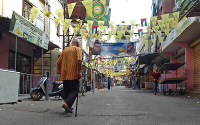 A man walks past closed shops in the aftermath of clashes between the Fatah movement and Islamists inside the Ein el-Hilweh Palestinian refugee camp in the southern coastal city of Sidon on August 1, 2023. (Mahmoud ZAYYAT / AFP)